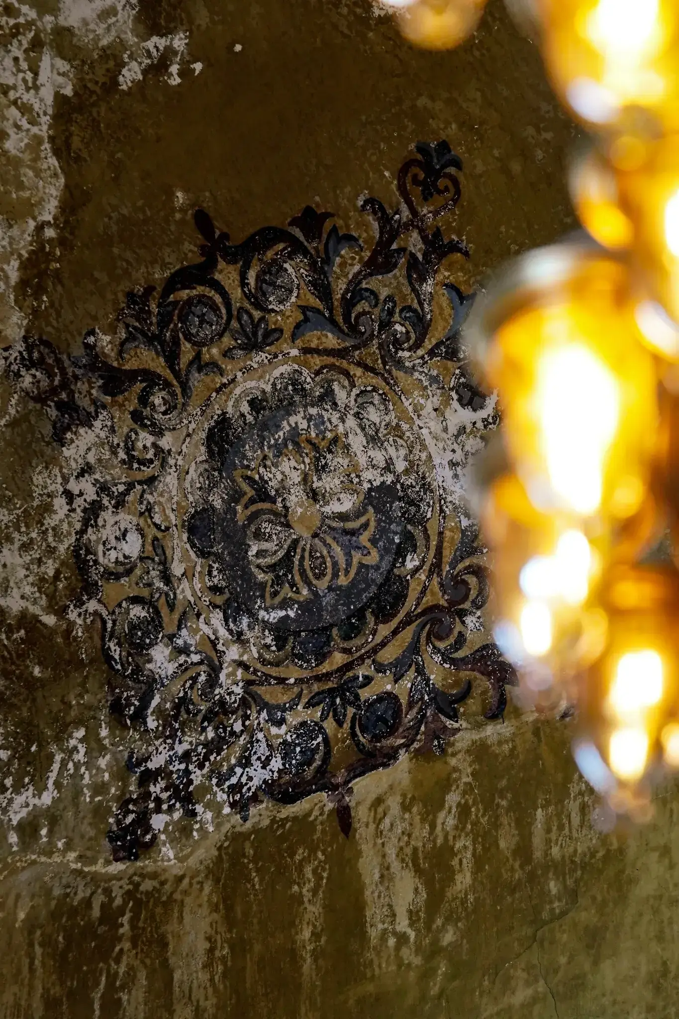 Ornamento floral otomano pintado sobre una superficie del techo, con el patrón repitiéndose hacia la bóveda.