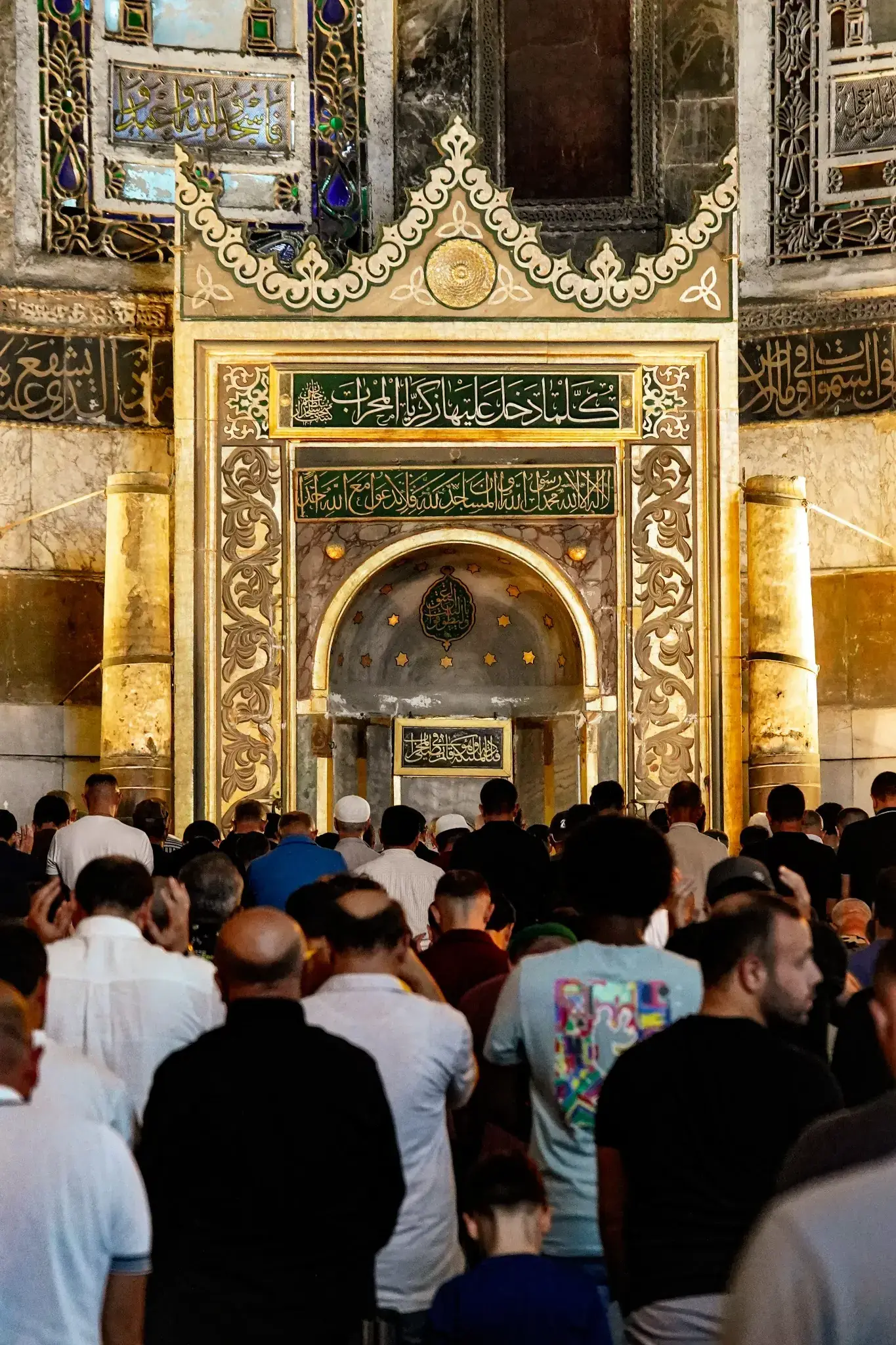 El mihrab durante la oración, con fieles en filas sobre la alfombra ante él.