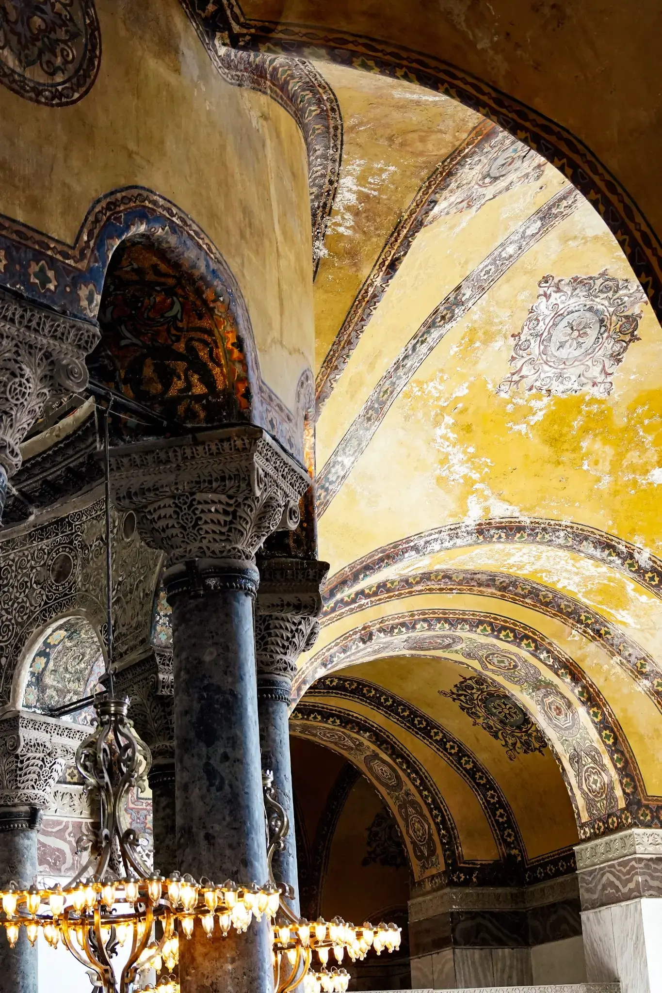 Un arco decorado que arranca de una columna de mármol, con su banda tallada en relieve.