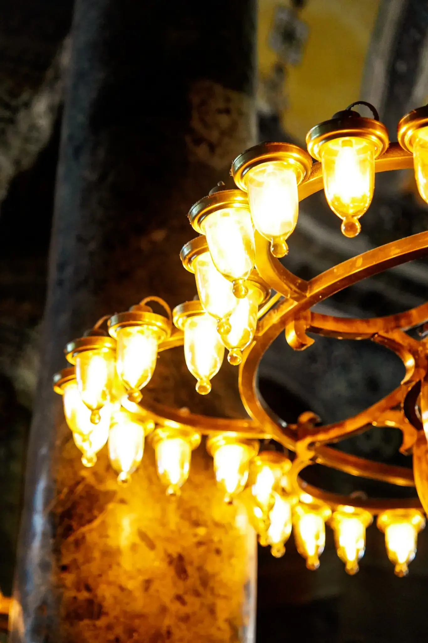 Detalle de una lámpara otomana, con su anillo de luces colgando bajo sobre el suelo.
